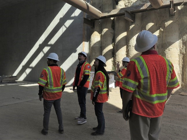 Students touring a high-speed rail construction site in Fresno, CA look up to analyze the structure.  
