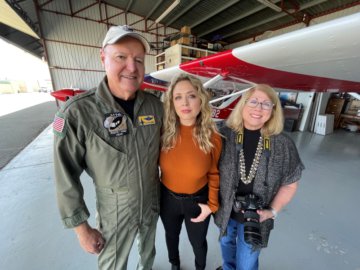 Julie Belanger, Pat Belanger, and Niki Britton standing in front of an airplane