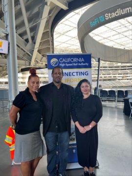 two women and one man standing in front of California High-Speed Rail Authority banner inside SoFi Stadium