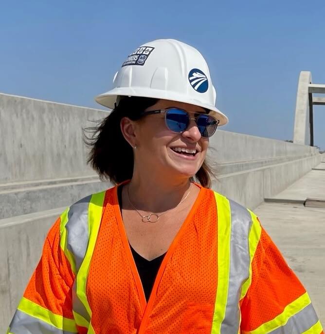 Woman in sunglasses and construction vest smiling
