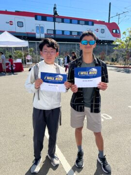 Young train enthusiasts hold I Will Ride signs at Caltrain’s 160th Anniversary event.