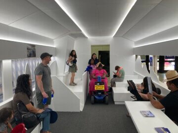 Visitors using the family area of the white mock-up trainset interior at the California State Fair.