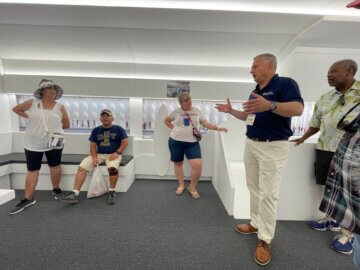 Contractor Frank Banko speaks with visitors on the amenities inside the white mock-up trainset interior at the California State Fair.