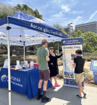 An Authority staff member speaking with two members of the public at an outreach event in Southern California.