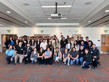 Group of 50 students and young professionals in formal attire. 