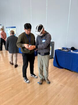 An attendee using a virtual reality headset to view the interior of a future high-speed train.