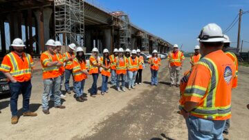 On-site engineering and construction staff talk to students next to the Hanford Viaduct high-speed rail structure.