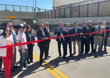 Dignitaries in front of a red ribbon at Tulare Street in Fresno.