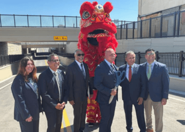 Dignitaries and Chinese lion dancers posing in front of Tulare Street in Fresno.