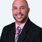 Portrait of Jerome Keene, Deputy City Manager for the City of Selma, wearing a black suit and pink shirt, posed against a plain white background.